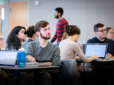 Students sitting in a classroom listening to speaker.