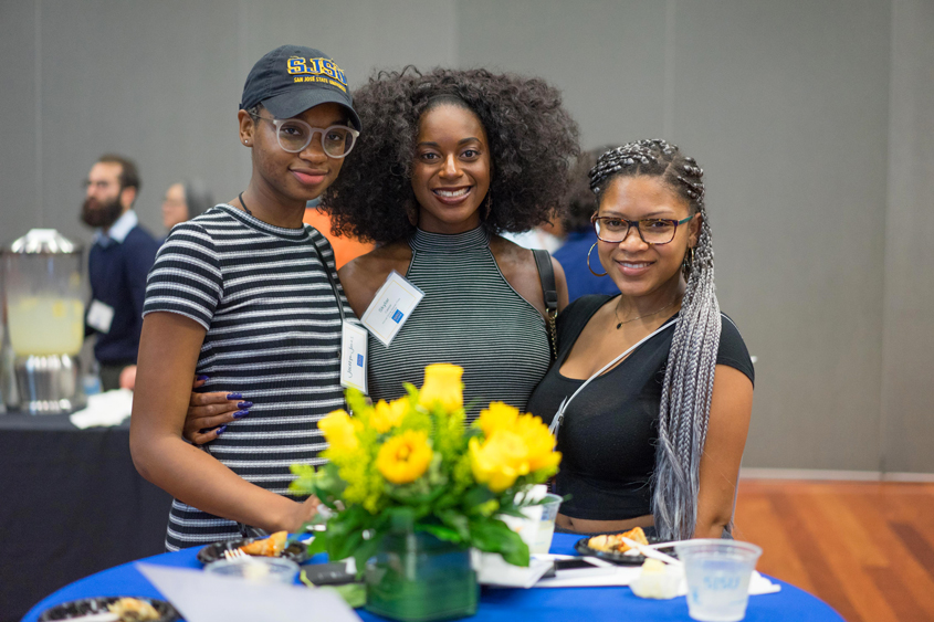 Students who received scholarships gather together around a table.