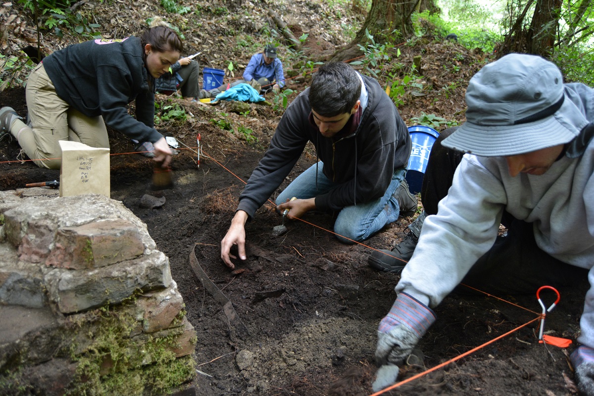 Three students working in a ditch