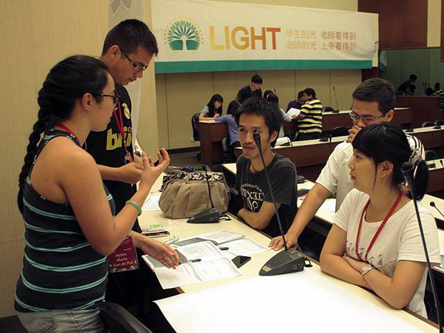 Helen Van de Pol confers with her team, which includes two other SJSU students, Jose (standing next to Helen) and Christian Ruiz (standing across from them in white shirt), while working on a geriatrics presentation, which won 2nd place overall at the conference.