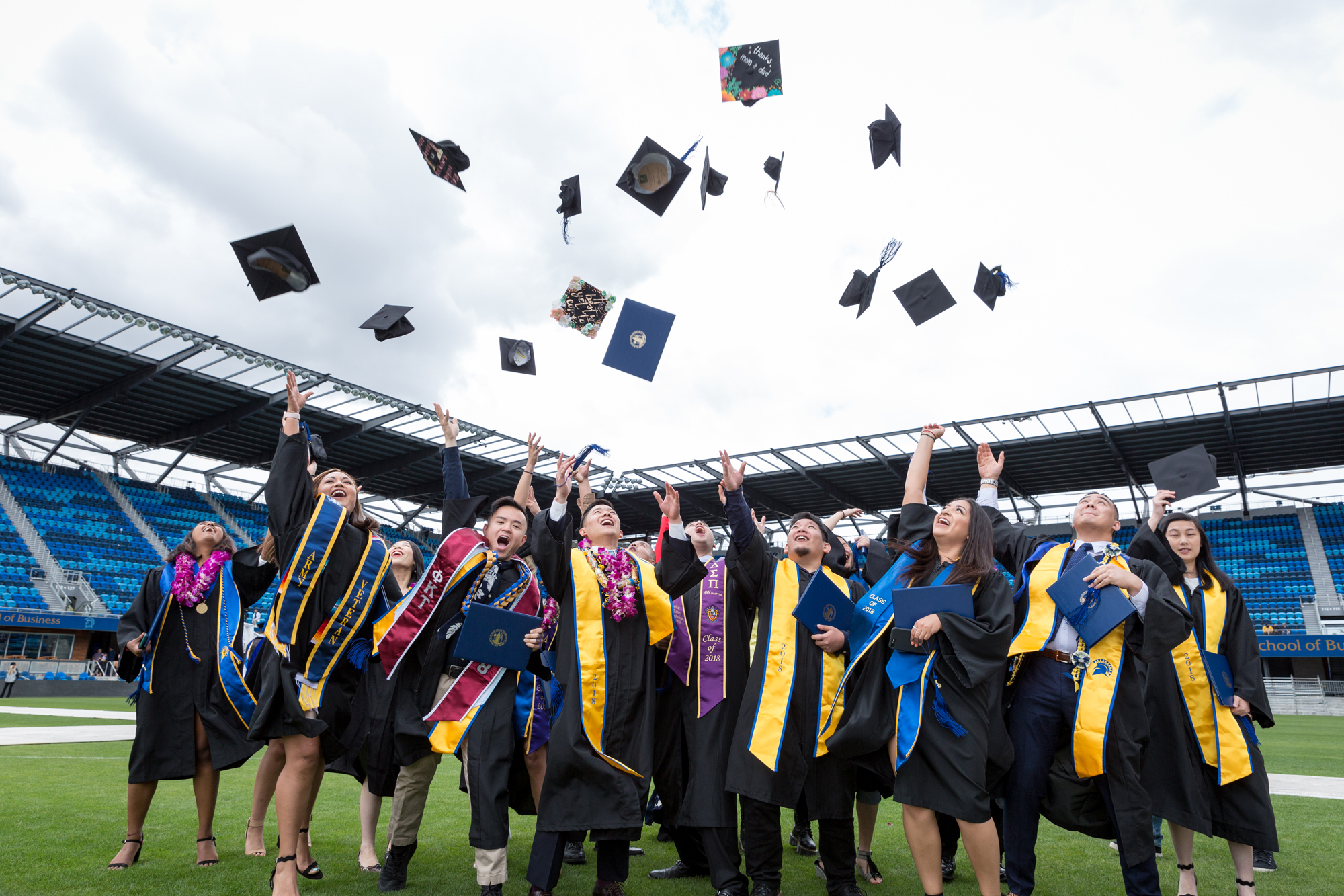 students graduating and throwing hats in the air