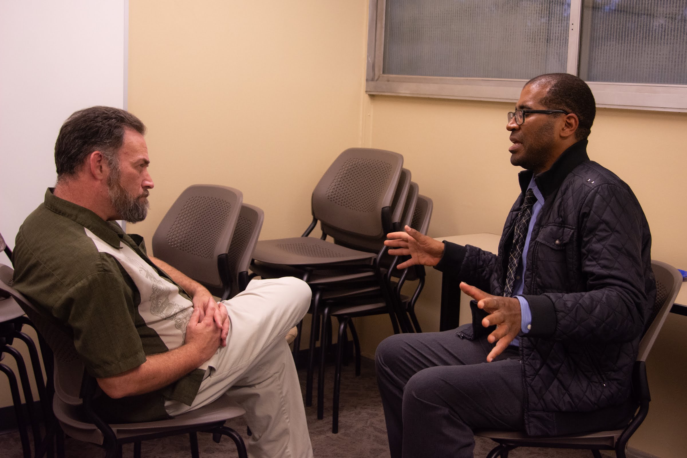 A professor actively listening to a student speak.