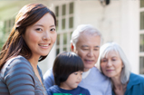 An asian woman with a child along with an elderly woman and man in the background.