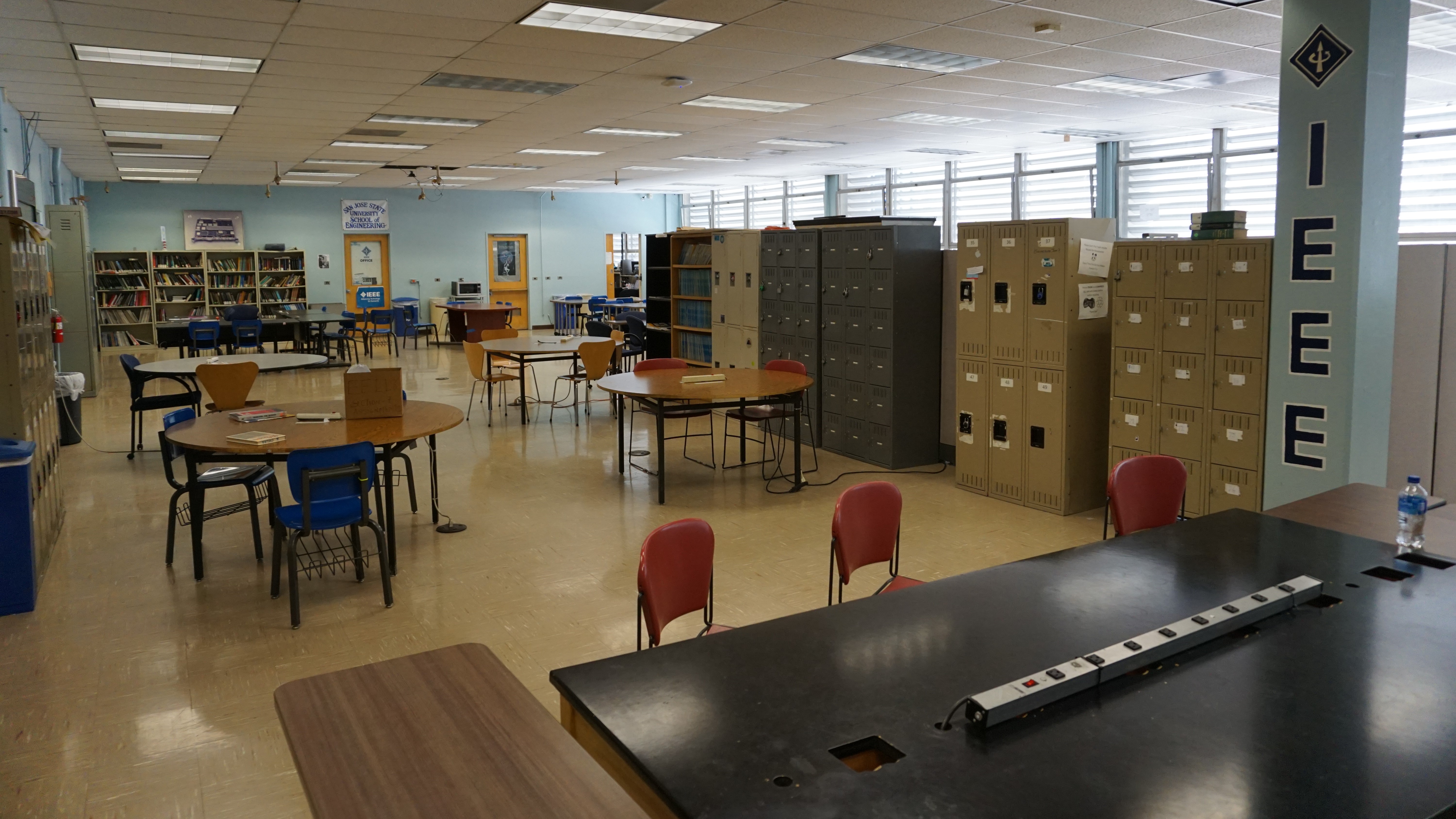 A large room with a few round tables set up. There's an IEEE banner on the right wall.