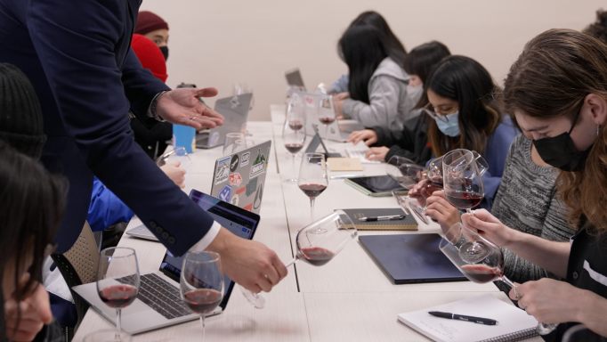 Professor showing hospitality students how to examine wine