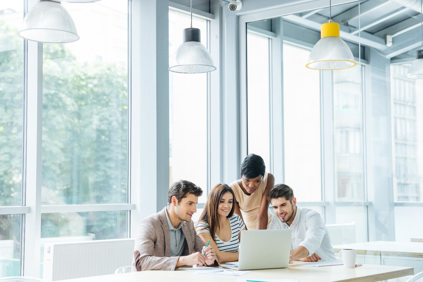 A group of people standing around a computer