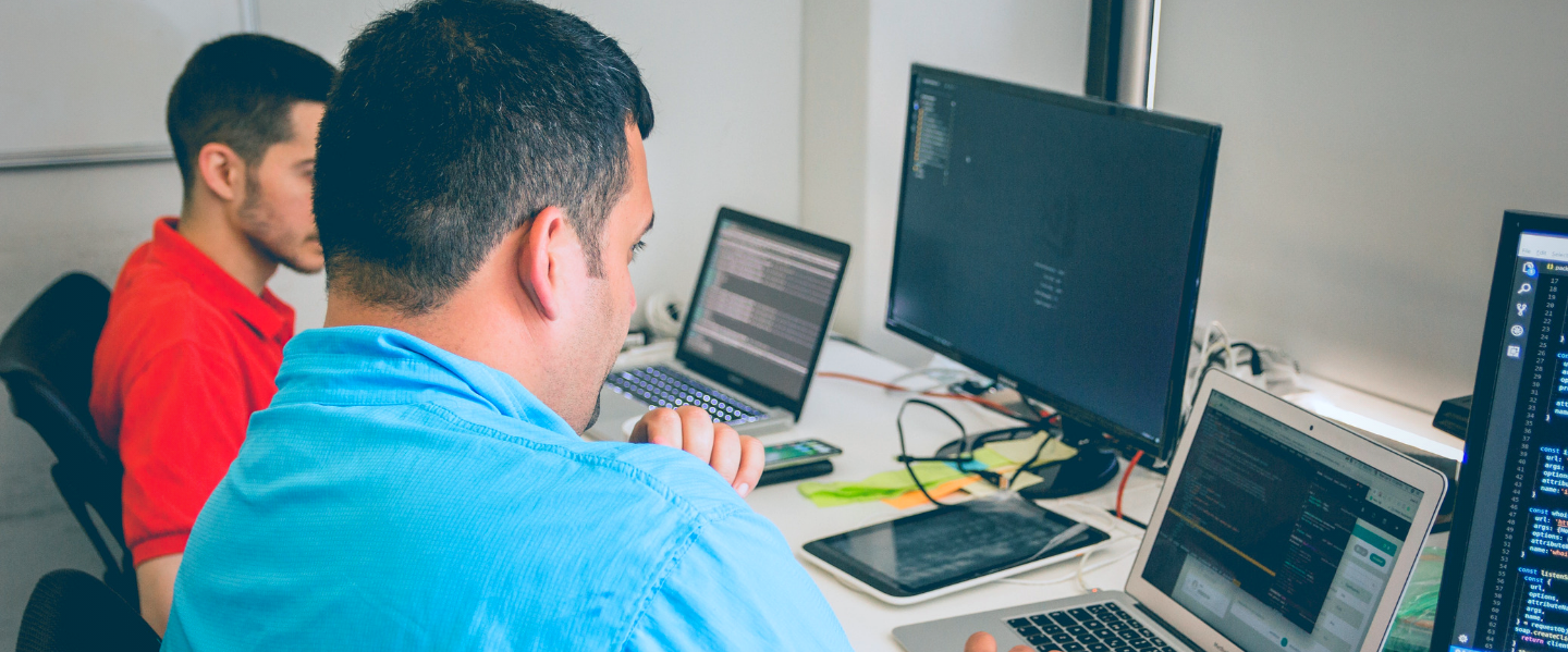 Two males use computers.