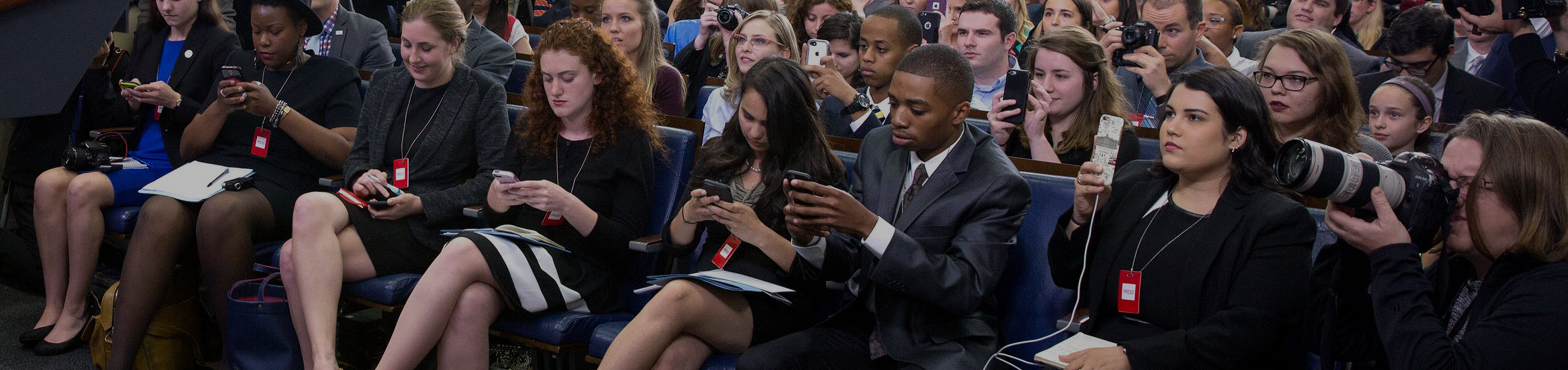 An audience of PR pros taking notes on their phones.