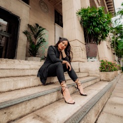 Photo of justice studies graduate student Samantha Magbulos sitting on the steps of a courthouse