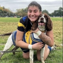 Photo of student scholarship recipient, Reyna Bautista, hugging brown and white dog