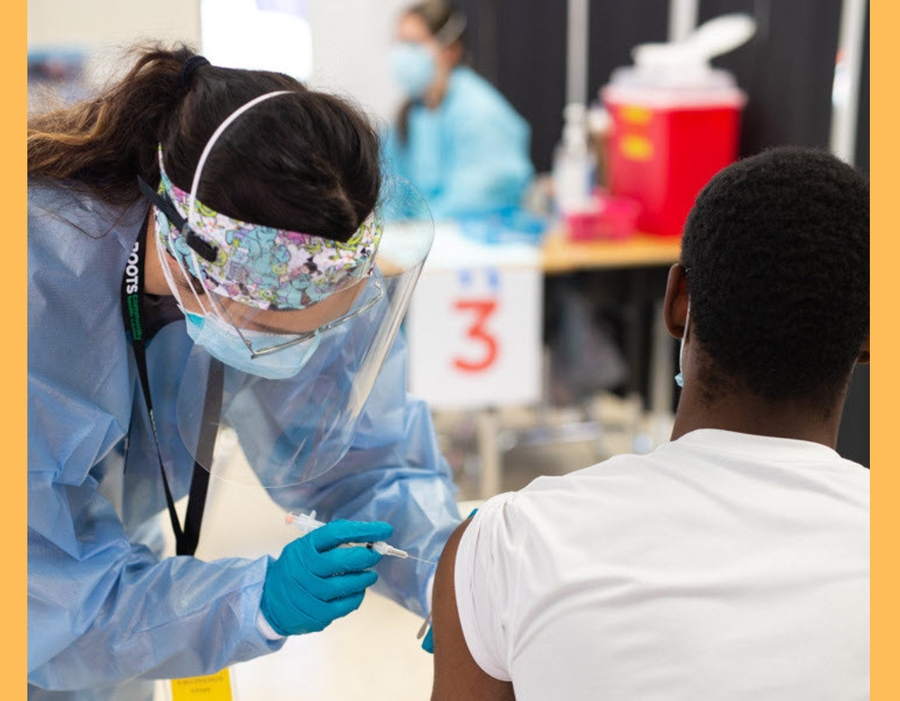 A student, wearing PPE, works in a community health clinic.