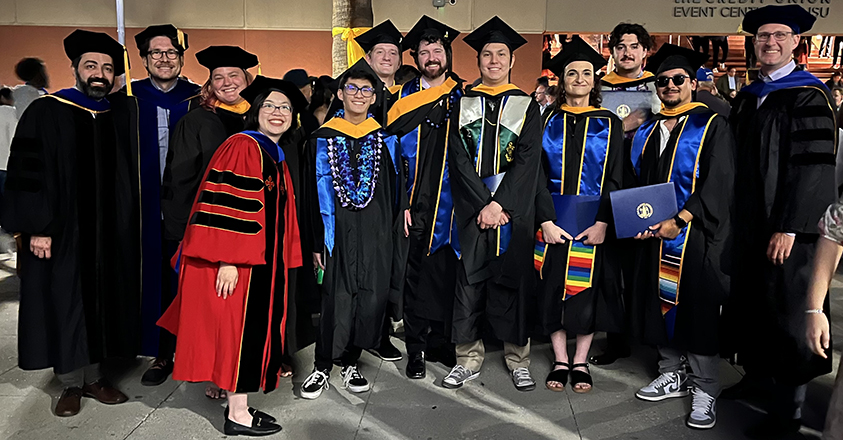 Photograph of students and faculty members in graduation regalia.