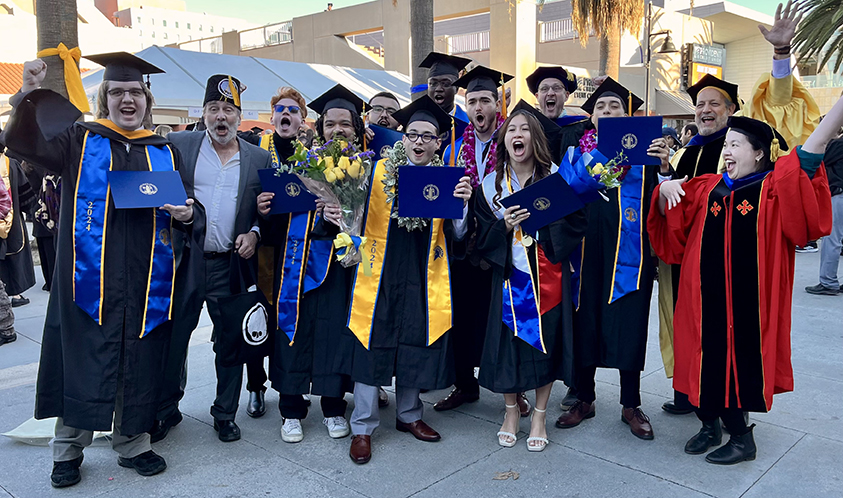 Group photo of students and faculty members in regalia.