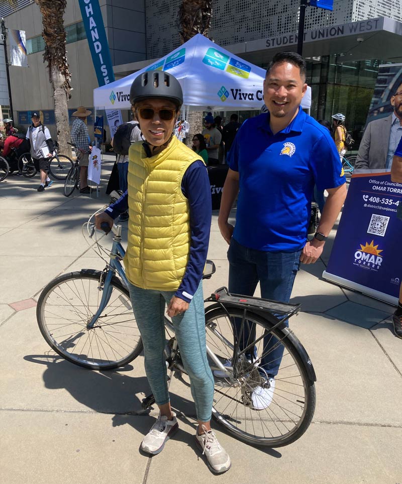 The president posing with her bike and a staff member at Viva Calle.