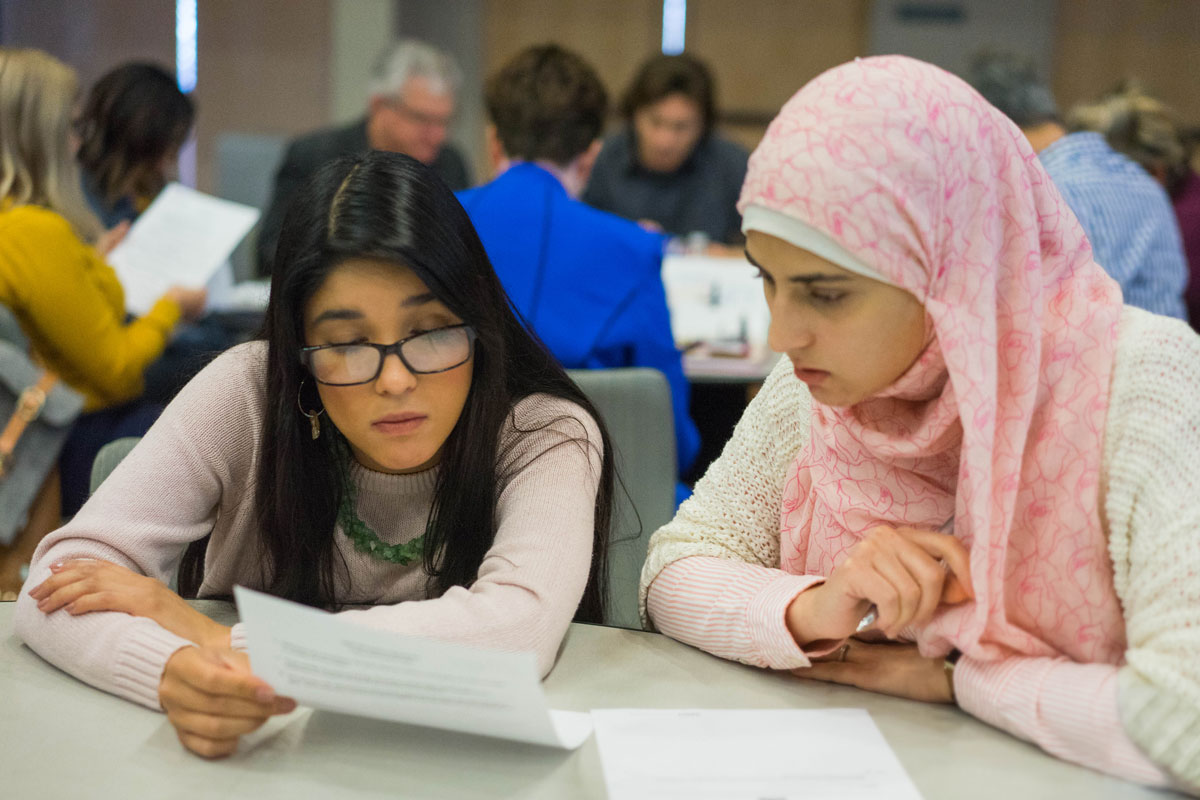 Two female students looking over informational material.