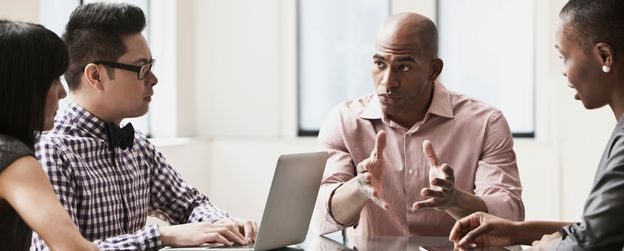 A seated person in a group setting explaining something