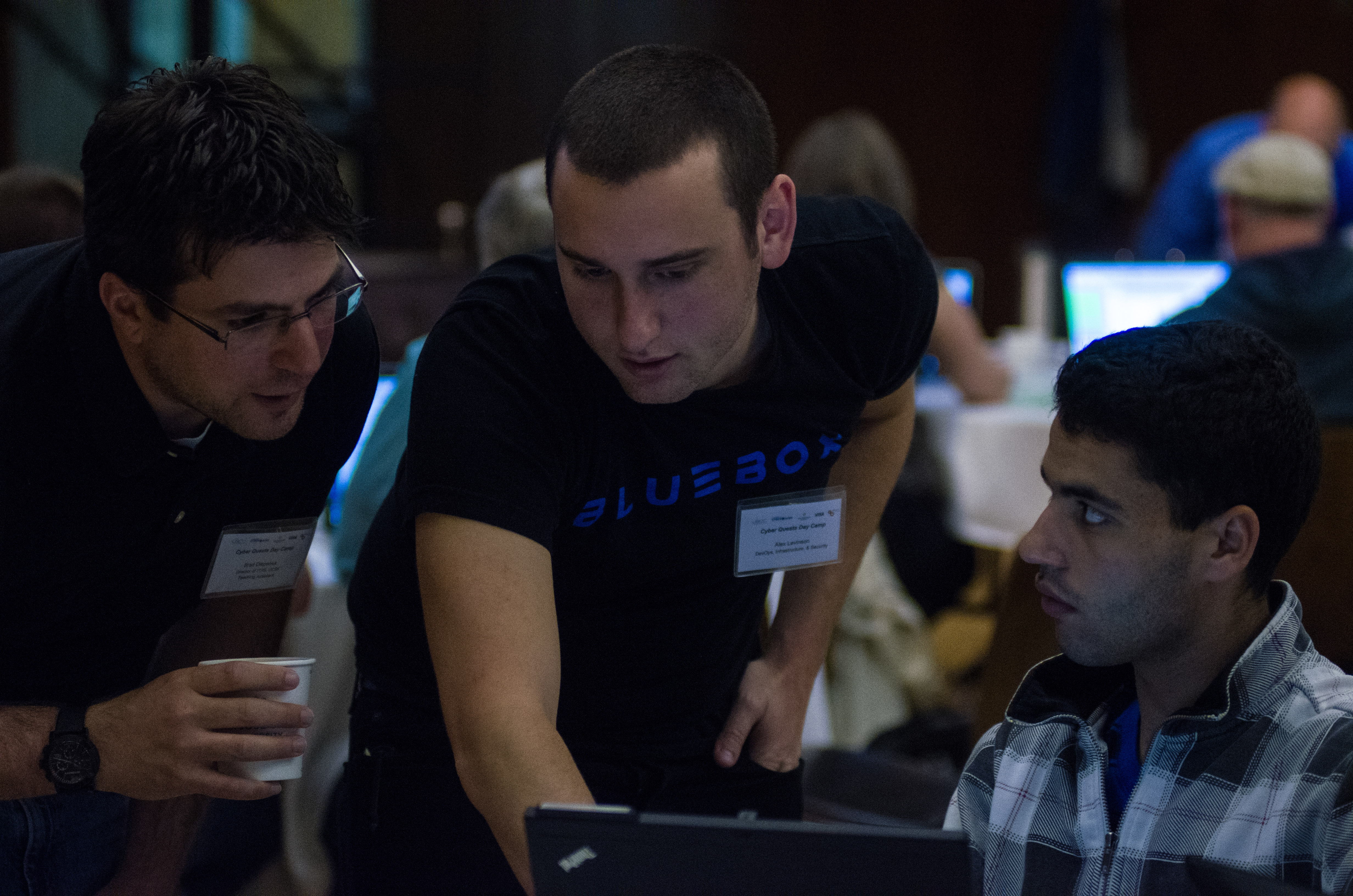 Three people looking at a computer