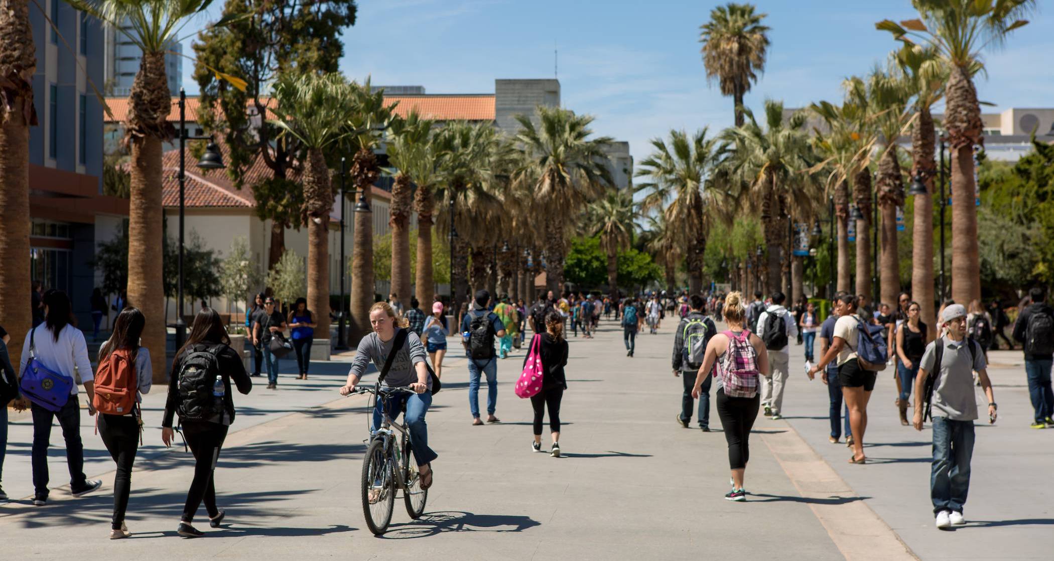 Photo, students walking on campus. Crowded area. 