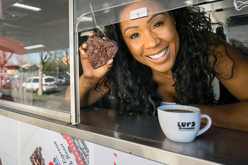 Andrea Lacy holding a brownie inside her food truck.