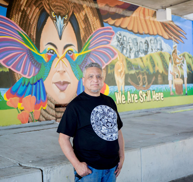 Alfonso Salazar posing in front of his mural.