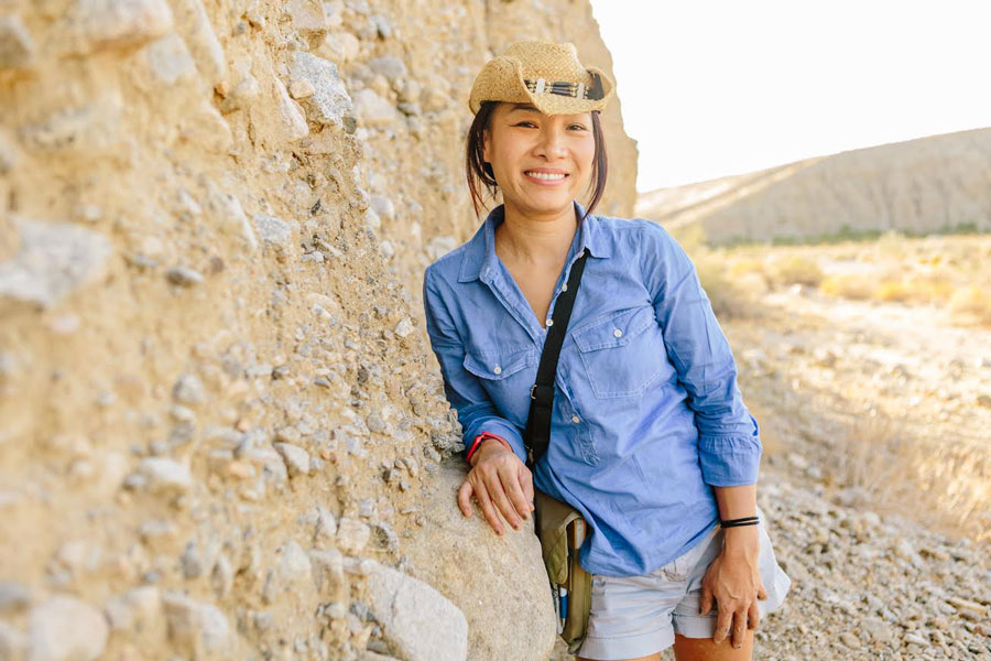 Kim Blisniuk leaning against a mountain wall.